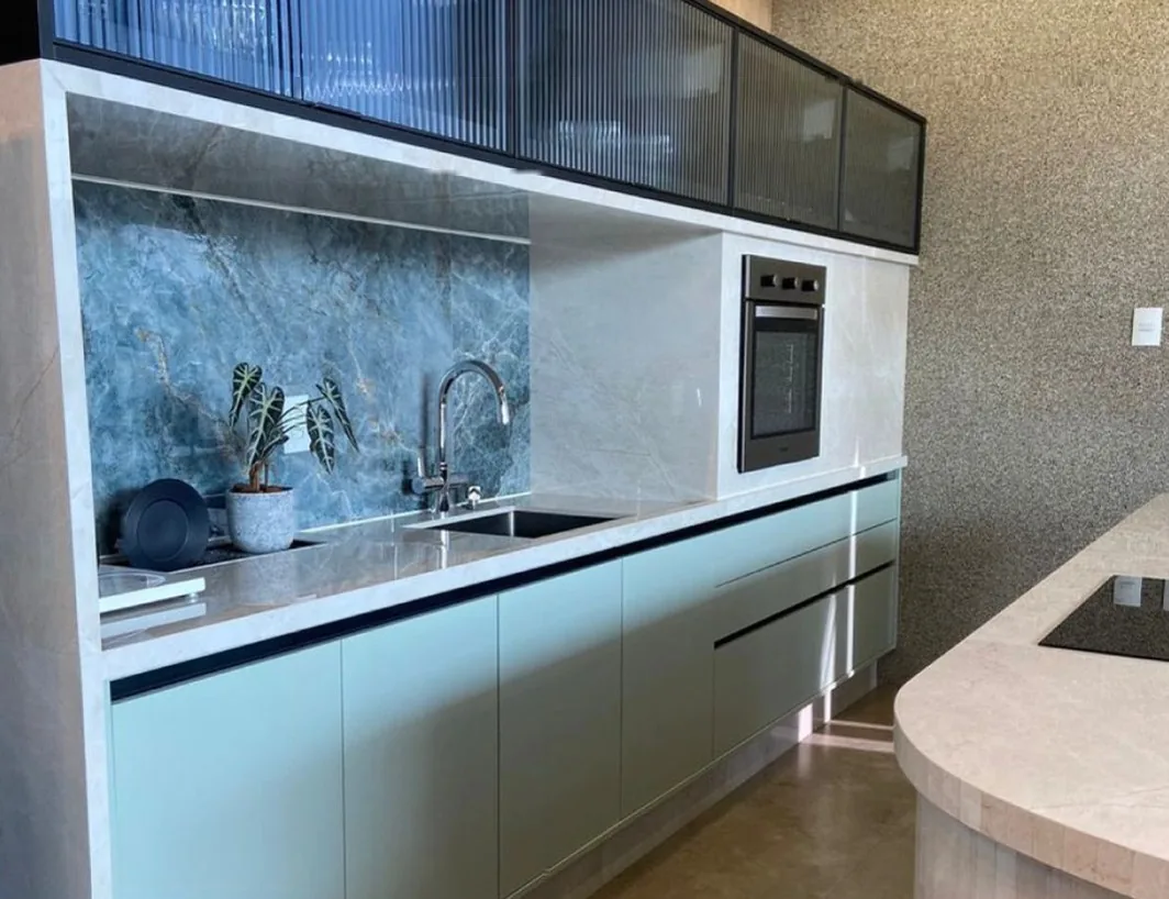 Cozinha linear em azul claro com armário aéreo de vidro